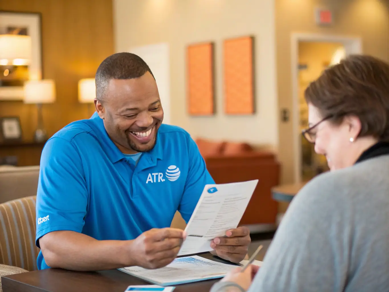 An image showing a satisfied customer reviewing their reduced bill with an AT&T Specialist, highlighting the savings achieved.